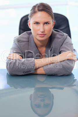 Portrait of a serious businesswoman leaning on her desk