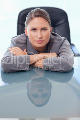 Portrait of a young businesswoman leaning on her desk