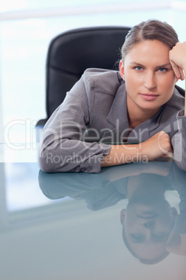 Portrait of a bored businesswoman leaning on her desk