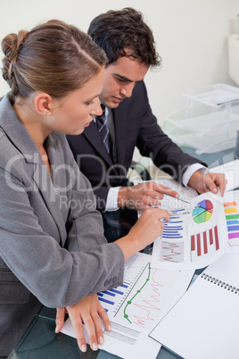 Portrait of an attractive business team studying statistics