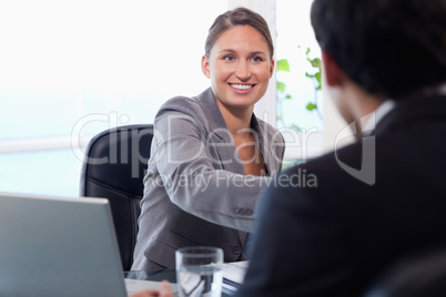 Smiling businesswoman welcomes customer