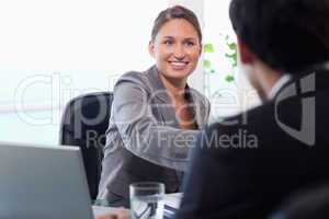 Smiling businesswoman welcomes customer