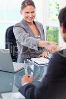 Smiling businesswoman welcomes customer in her office