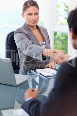 Businesswoman welcomes customer in her office