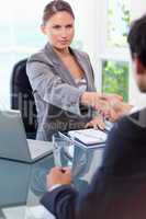 Businesswoman welcomes customer in her office