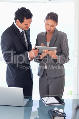Tradesman explaining functionality of tablet to his colleague