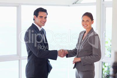 Side view of smiling trade partner shaking hands