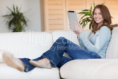 Smiling woman with tablet on the couch