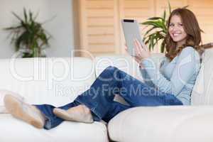 Smiling woman with tablet on the couch