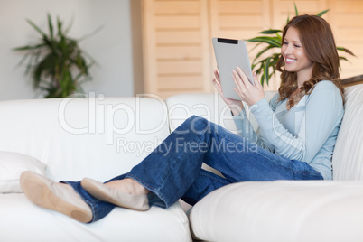 Smiling woman with tablet on the sofa
