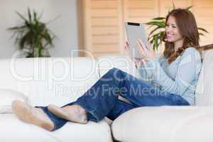 Smiling woman with tablet on the sofa