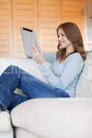 Smiling woman on the couch with her tablet