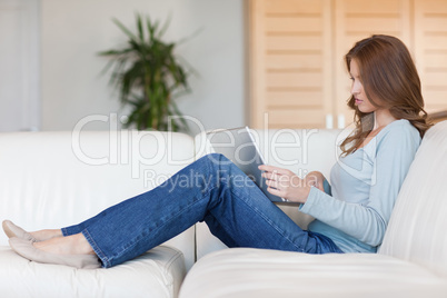 Woman sitting on the couch while working on her laptop