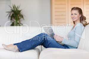 Smiling woman with laptop on the couch