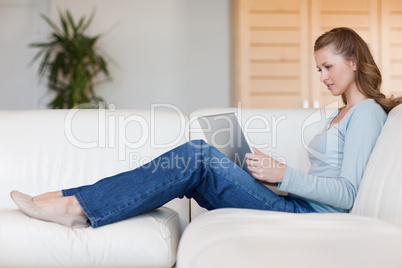 Woman working on her notebook on the sofa