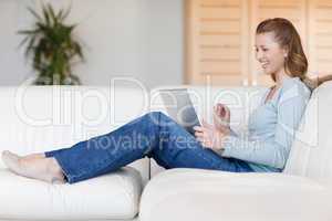 Laughing woman with her laptop on the sofa