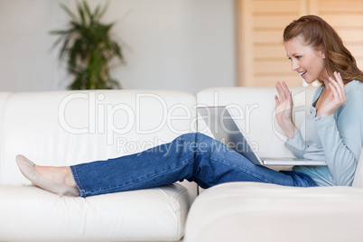 Young woman on the sofa waiting for online auction to be over