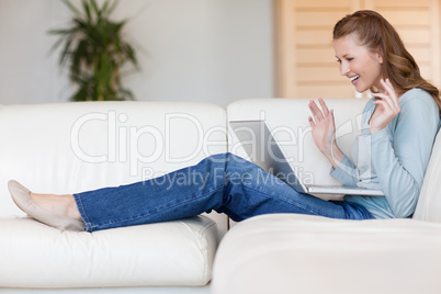 Happy smiling woman on the sofa with her laptop