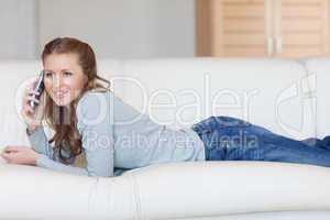 Young female phoning on the sofa