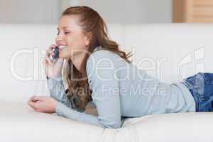 Female on the sofa having a joyful conversation on the phone