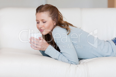 Young woman enjoying a coffee break on the sofa