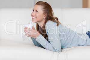 Young female enjoying a coffee break on her couch