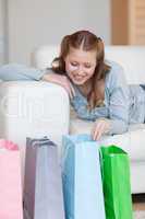 Woman on the sofa looking in her shopping bags