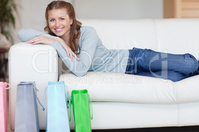 Woman relaxing on the sofa next to her shopping