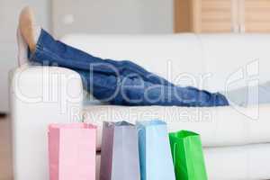 Female legs resting on sofa after shopping tour