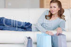 Woman on the sofa with her shopping next to her