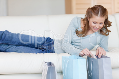 Female on the sofa looking into shopping bags