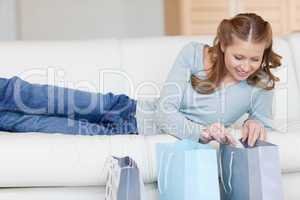 Female on the sofa looking into shopping bags