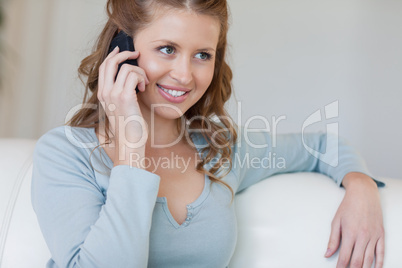 Woman sitting on the sofa listening to caller