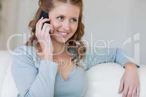 Woman sitting on the sofa listening to caller
