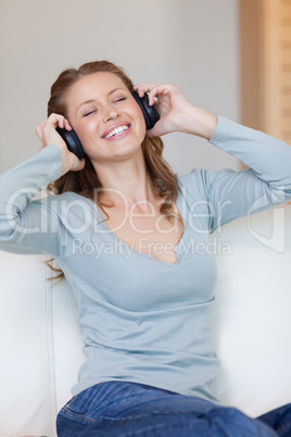 Young woman enjoying music on the sofa