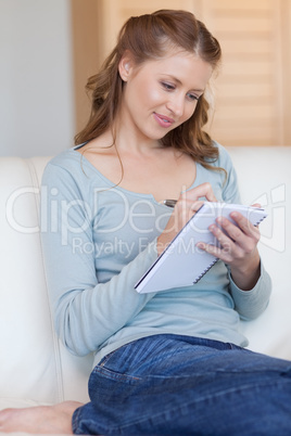 Woman taking notes on her sofa