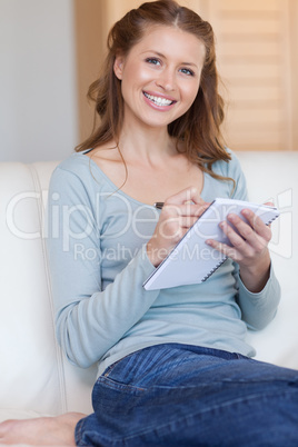 Woman taking notes on her couch