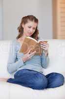 Woman on the sofa focused on her book