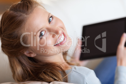 Shadowing smiling woman on the sofa with tablet