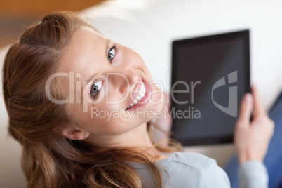 Above view of smiling woman with tablet on the sofa