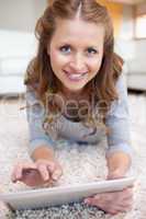 Smiling woman on the floor with her tablet