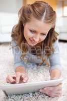 Woman lying on the floor working on her tablet