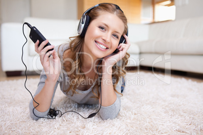 Woman lying on the floor enjoying music