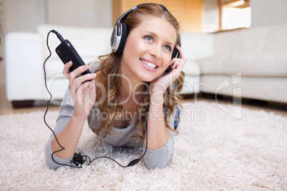 Woman lying in the living room enjoying music