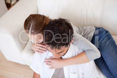 Woman hugging her boyfriend on the sofa