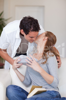 Woman giving her boyfriend a small kiss as thanks for a present