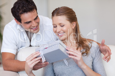 Woman opening the gift she got from her boyfriend