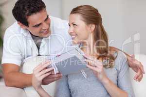 Woman smiling happily about the present she just got from her bo