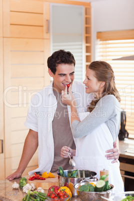 Man trying the meal his girlfriend is preparing