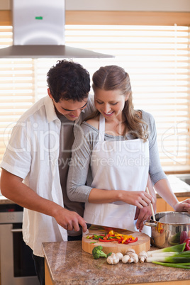 Man cutting ingredients to help his girlfriend